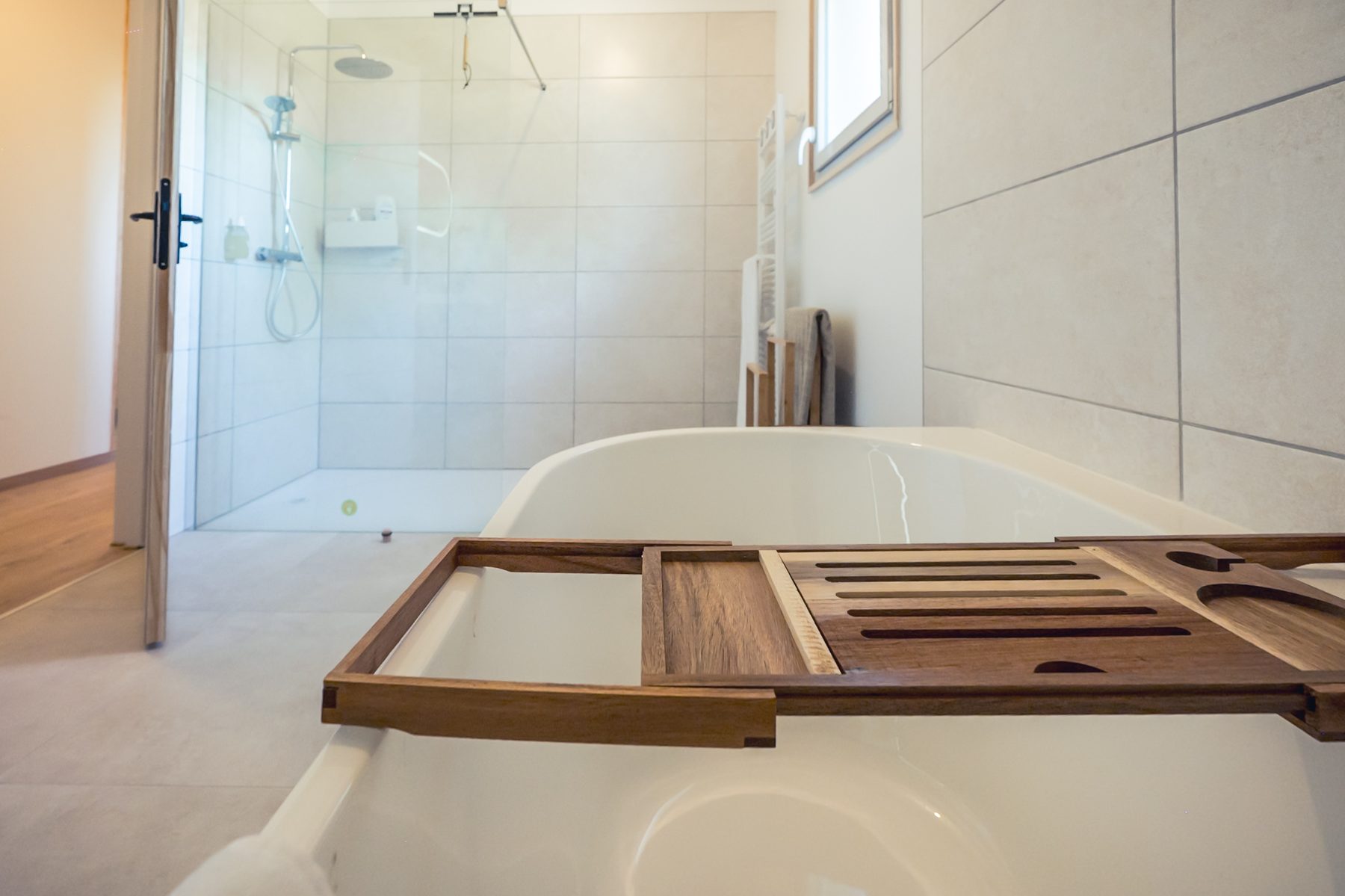 Salle de bain avec baignoire, douche et finitions claires